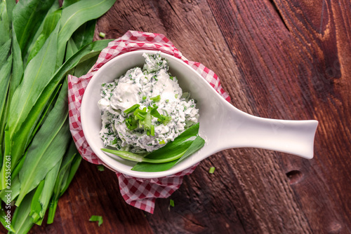 Spread of freshly harvested leaves of wild garlic (Allium ursinum) on a rustic wooden board