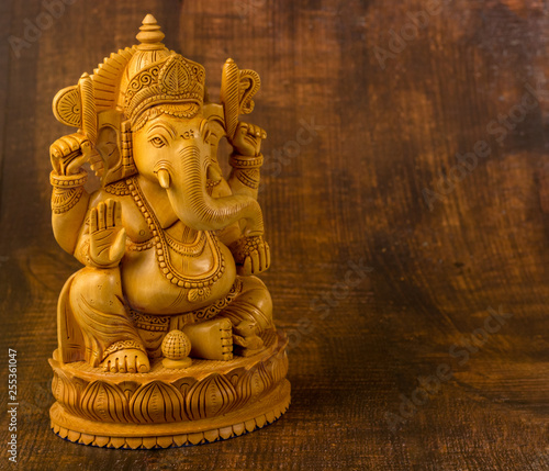 Ganesha statue on a wooden background