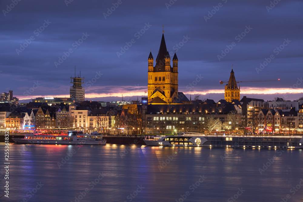 Panorama Köln mit der Groß St. Matrins Kirche und der Kölner Altstadt mit Blick über den Rhein,  am Horizont die letzten Sonnenstrahlen und Königsblauer Himmel 