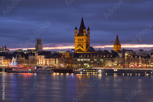 Panorama Köln mit der Groß St. Matrins Kirche und der Kölner Altstadt mit Blick über den Rhein,  am Horizont die letzten Sonnenstrahlen und Königsblauer Himmel 