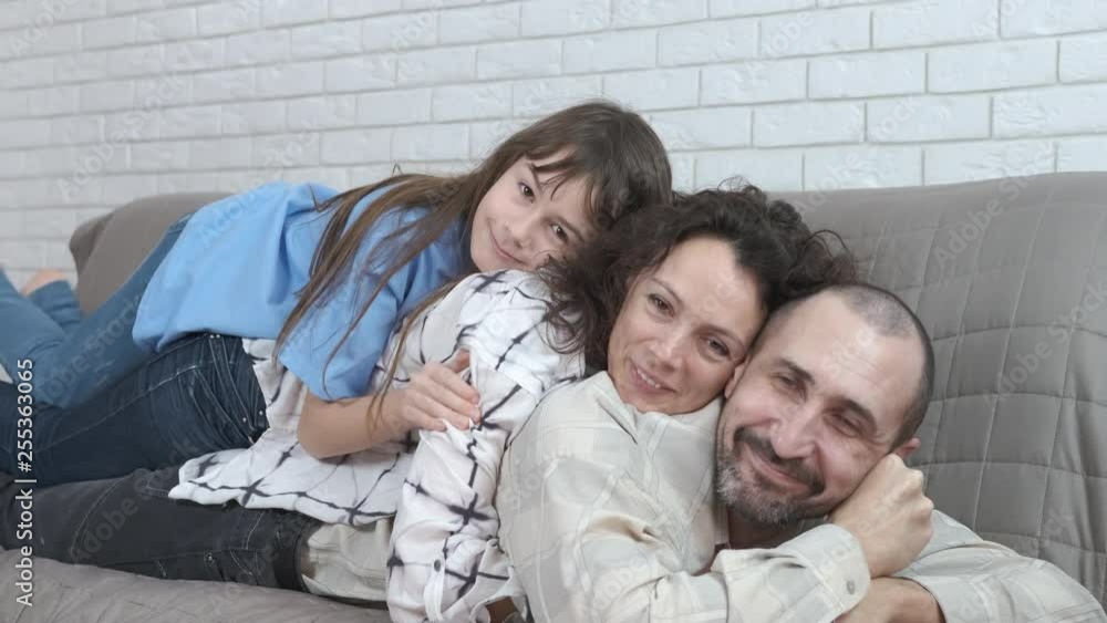 Portrait of a happy family. A pyramid of parents and children. Mom lies on dad's back, daughters lie on mom's back. Portrait of a happy family. A pyramid of parents and children. Mom lies on dad's back, daughters lie on mom's back.