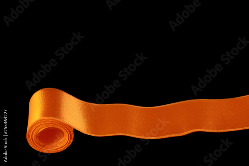 one orange horizontal ribbon isolated on black