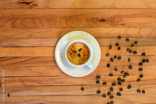 Taza de café y granos de café en fondo de madera. Vista superior.