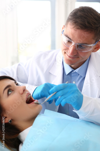 woman at the reception of a male dentist examining teeth