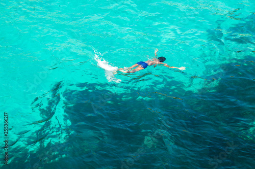 Boy swimming in blue turquoise water