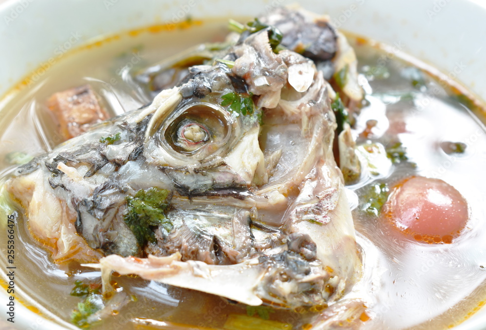 spicy boiled Tilapia head fish in tom yum soup on bowl spicy boiled Tilapia head fish in tom yum soup on bowl