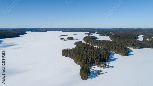 Aerial view of beautiful winter lake and forest in National park in Fnland. Winter scenery from above..