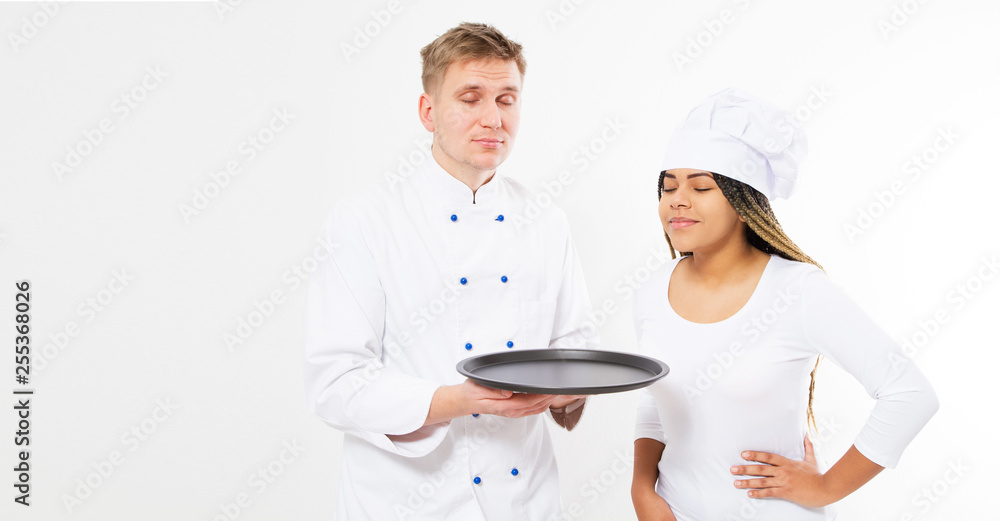 Female and male chefs hold an empty tray and inhale the pleasant smell of food isolated Copy space. Female and male chefs hold an empty tray and inhale the pleasant smell of food isolated Copy space.