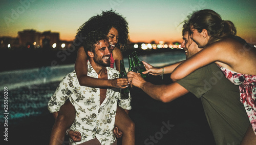 Photography Happy friends drinking beer and having fun on the beach after sunset - Soft focu