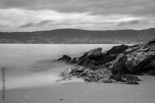 Beautiful long exposure shot of seascape and beach in black and white in Pontevedra, Galicia, Spain.
