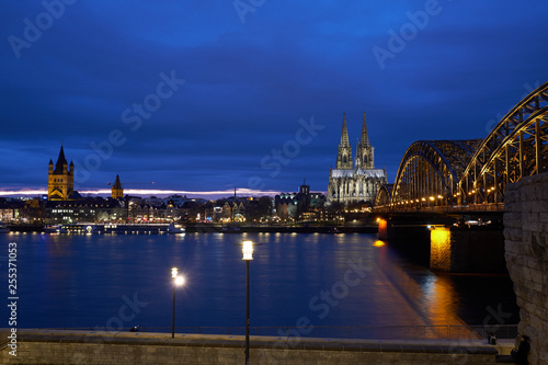 Kölner Dom und Groß St. Martin Kirche mit Blick auf die Hohenzollernbrücke und die Kölner Altstadt und den Fischmarkt während Sonnenuntergang , Blaue Stunde