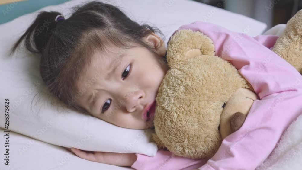 Little asian girl crying with her teddy bear have the tears on her face on the bed, Parenthood and sad moments concept Little asian girl crying with her teddy bear have the tears on her face on the bed, Parenthood and sad moments concept