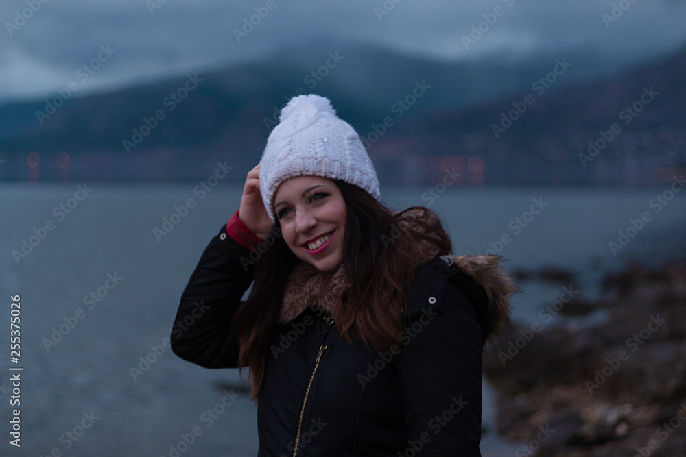 Young girl facing a lake during a cloudy day Young girl facing a lake during a cloudy day