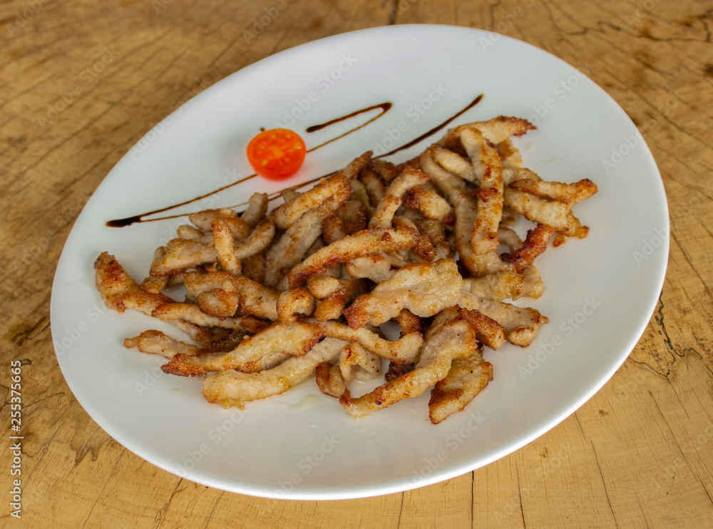 Crispy fried pork slices. Garnished with cherry tomatoes and balsamic sauce. Crispy fried pork slices. Garnished with cherry tomatoes and balsamic sauce.
