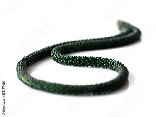 Dark green beaded necklace isolated on white background close up