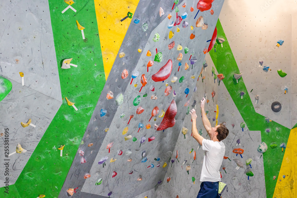 climber explores and develops a route on a climbing wall in the boulder hall