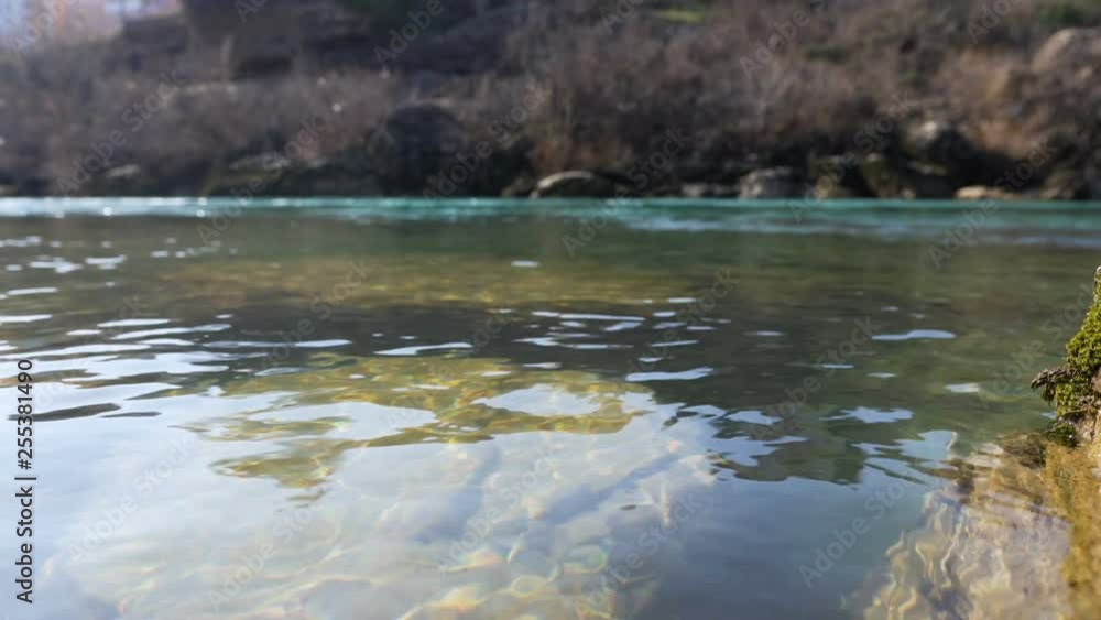 River with reflection of sunlight and stones under water River with reflection of sunlight and stones under water