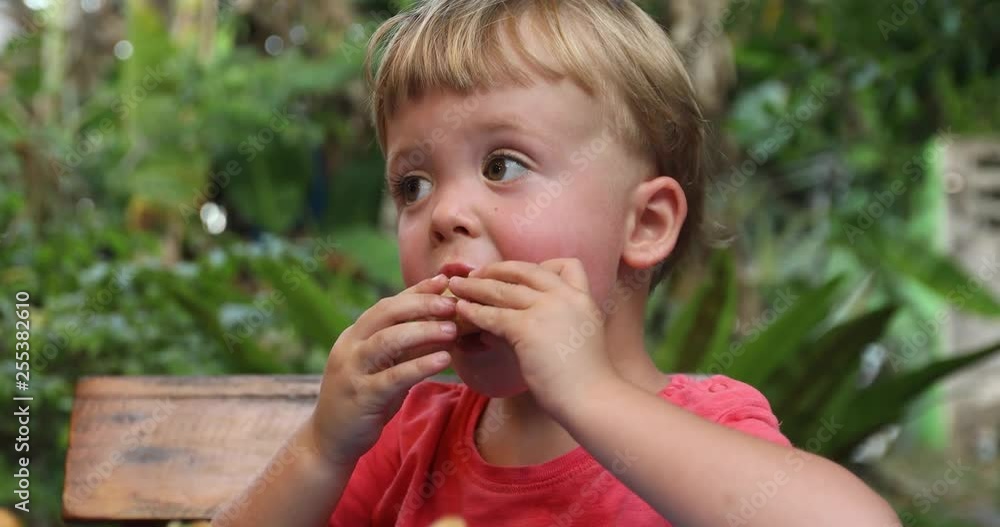 Little cute boy pink tshirt eats appetizing bun nature Little cute boy pink tshirt eats appetizing bun nature
