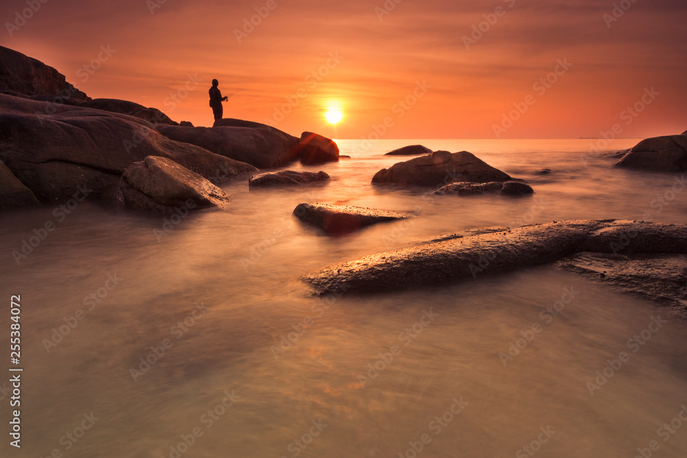 silhouette fishing man at the sea during sunset