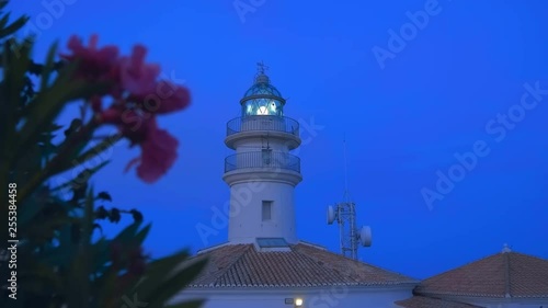 Wallpaper Mural The lighthouse is shining by sector lights and telecommunication tower with satellite dishes stands on a cliff on the shores of the Mediterranean Sea against the night blue sky Torontodigital.ca