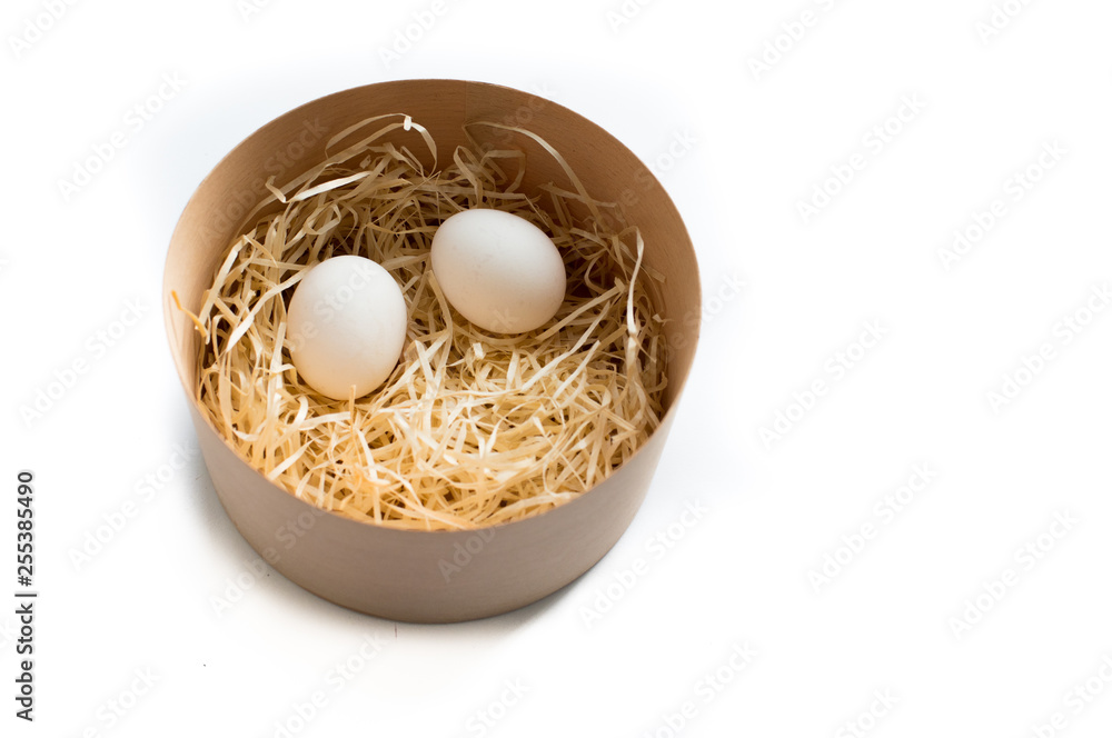 Two Easter eggs in round wooden box isolated on white background, top view Two Easter eggs in round wooden box isolated on white background, top view
