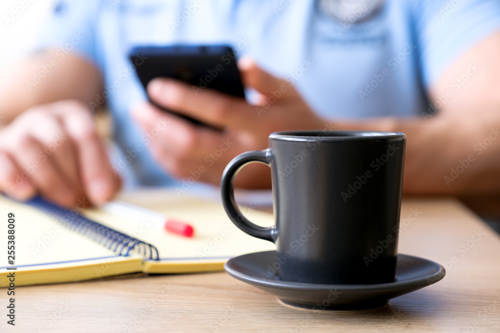 The man behind the Cup of coffee he reads a text. The man behind the Cup of coffee he reads a text.