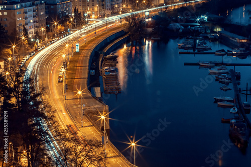 Long Time Exposure with Blurred Cars on Street. Night Scene with Boats on River. Prague, Czech Republic.