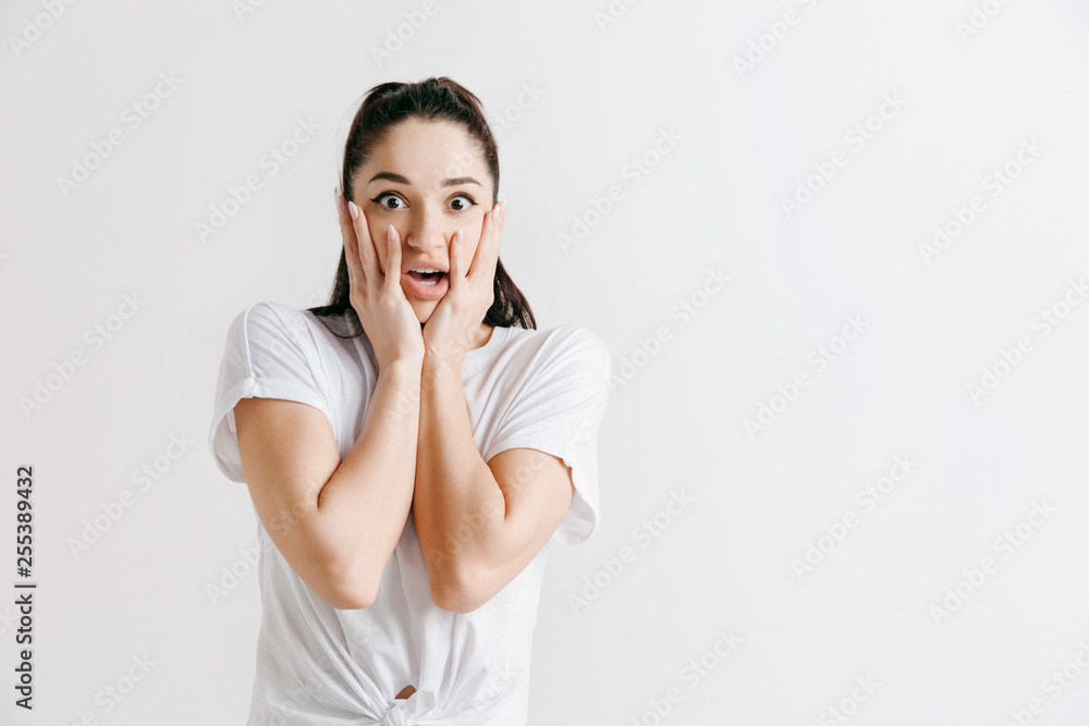 Wow. Beautiful female half-length front portrait isolated on gray studio backgroud. Young emotional surprised woman standing with open mouth. Human emotions, facial expression concept. Wow. Beautiful female half-length front portrait isolated on gray studio backgroud. Young emotional surprised woman standing with open mouth. Human emotions, facial expression concept.