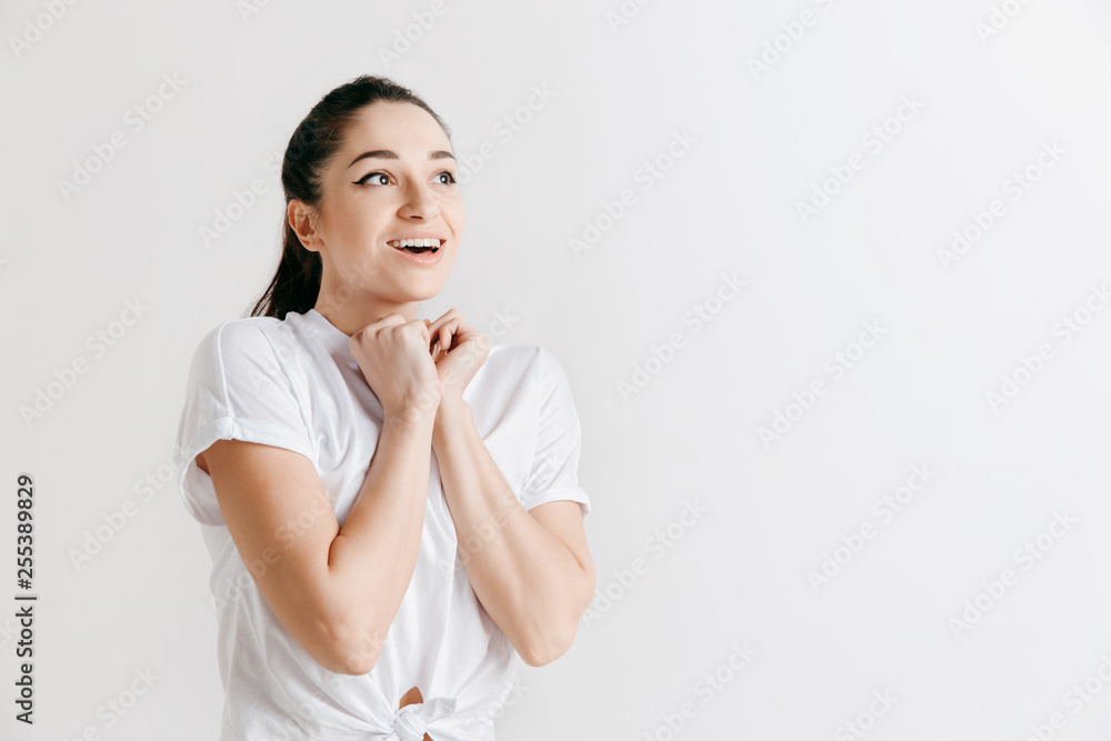 Wow. Beautiful female half-length front portrait isolated on gray studio backgroud. Young emotional surprised woman standing with open mouth. Human emotions, facial expression concept. Wow. Beautiful female half-length front portrait isolated on gray studio backgroud. Young emotional surprised woman standing with open mouth. Human emotions, facial expression concept.