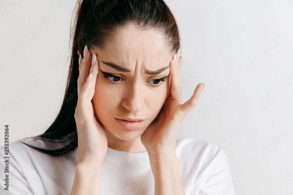 Woman having headache. Isolated on gray background. Businesswoman standing with pain isolated on gray background. Female half-length portrait. Human emotions, facial expression concept. Woman having headache. Isolated on gray background. Businesswoman standing with pain isolated on gray background. Female half-length portrait. Human emotions, facial expression concept.
