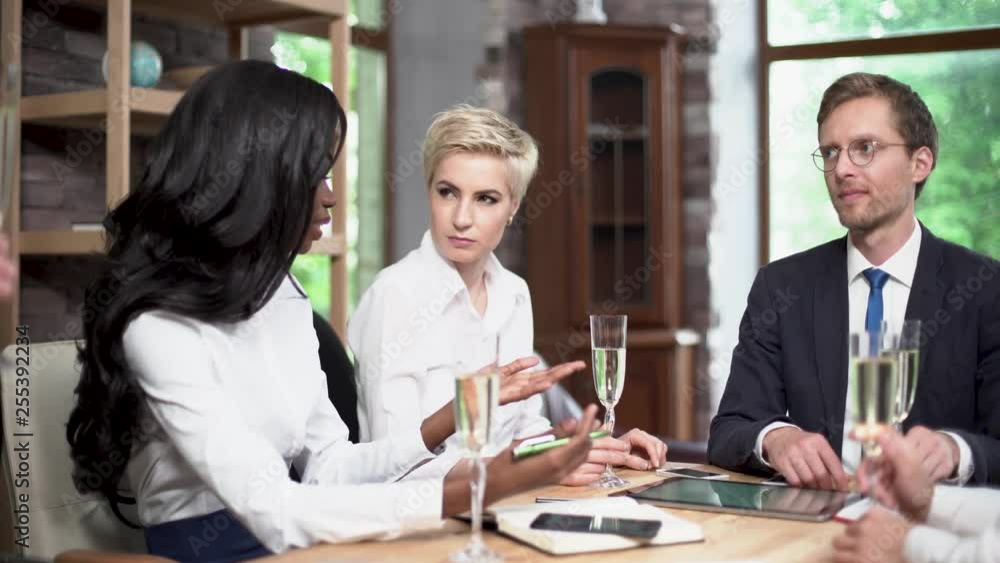 Young Managers of a Large Company are Drinking Champagne in the Office After Successful Negotiations. Young Managers of a Large Company are Drinking Champagne in the Office After Successful Negotiations.