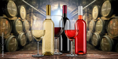 Collection of equisite red white and rose wine bottle glasseson wooden table  in front of old rustic winery cellar background photo