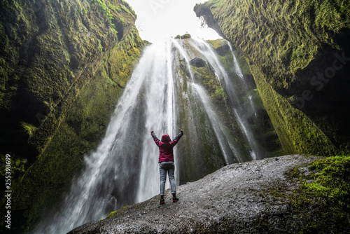 Traveler stunned by Gljufrabui waterfall cascade in Iceland. Located at scenic Seljalandsfoss waterfall South of Iceland, Europe. It is top beautiful destination of popular tourist travel attraction. photo