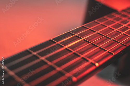 Gitarrenhals mit Gitarrensaiten mit rotem Licht von oben