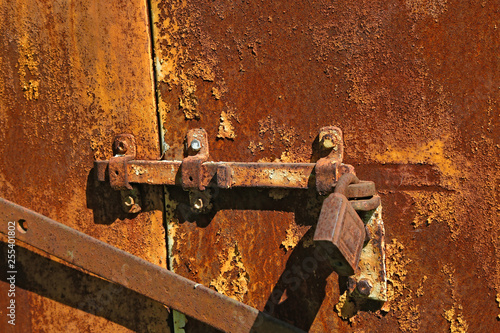 old rusty bolt with a lock on iron gate
