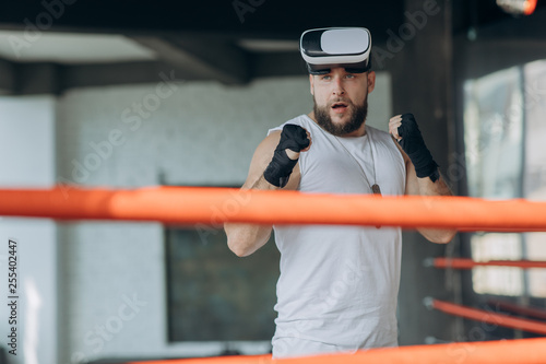 Muscular man in VR goggles and boxing gloves