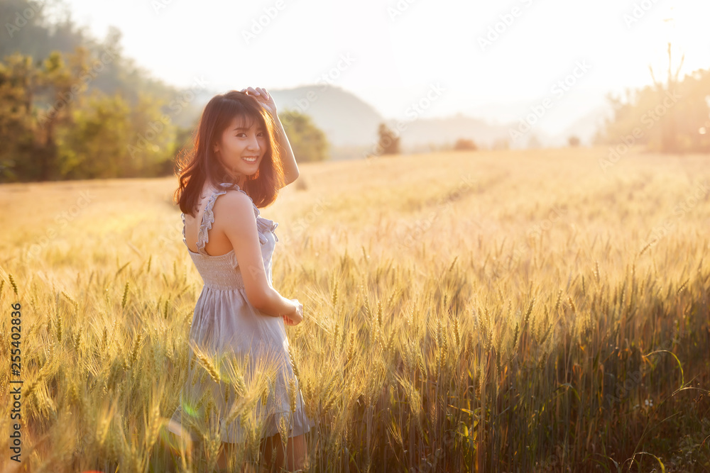 Beautiful and happy asian woman enjoying life in barley field at sunset. Beautiful and happy asian woman enjoying life in barley field at sunset.