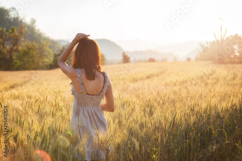 Wallpaper Mural Beautiful and happy asian woman enjoying life in barley field at sunset. Torontodigital.ca
