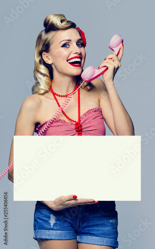 woman with phone and blank signboard, dressed in pin-up style