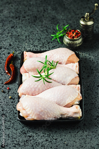 Raw chicken legs, spicy marinated drumsticks in cast iron sheet pan. Selective focus, space for text.