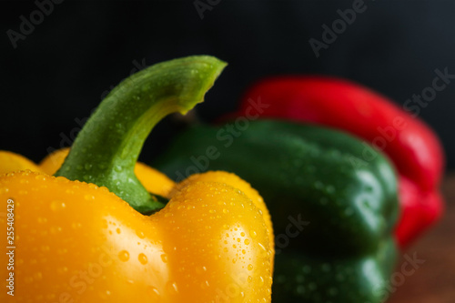 yellow green red bell peppers with water drops close view selective focus effect