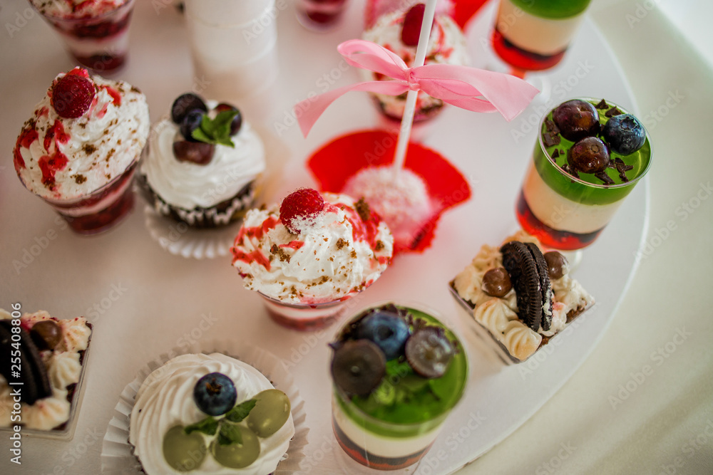 The bright cupcakes are laid out on the trays The bright cupcakes are laid out on the trays