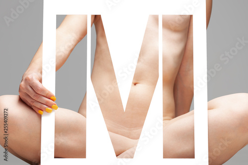 Fotografie nude girl holding stencil letter m