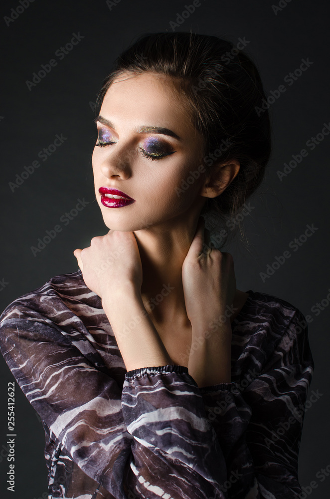 Young adult girl with beautiful evening makeup on a black background