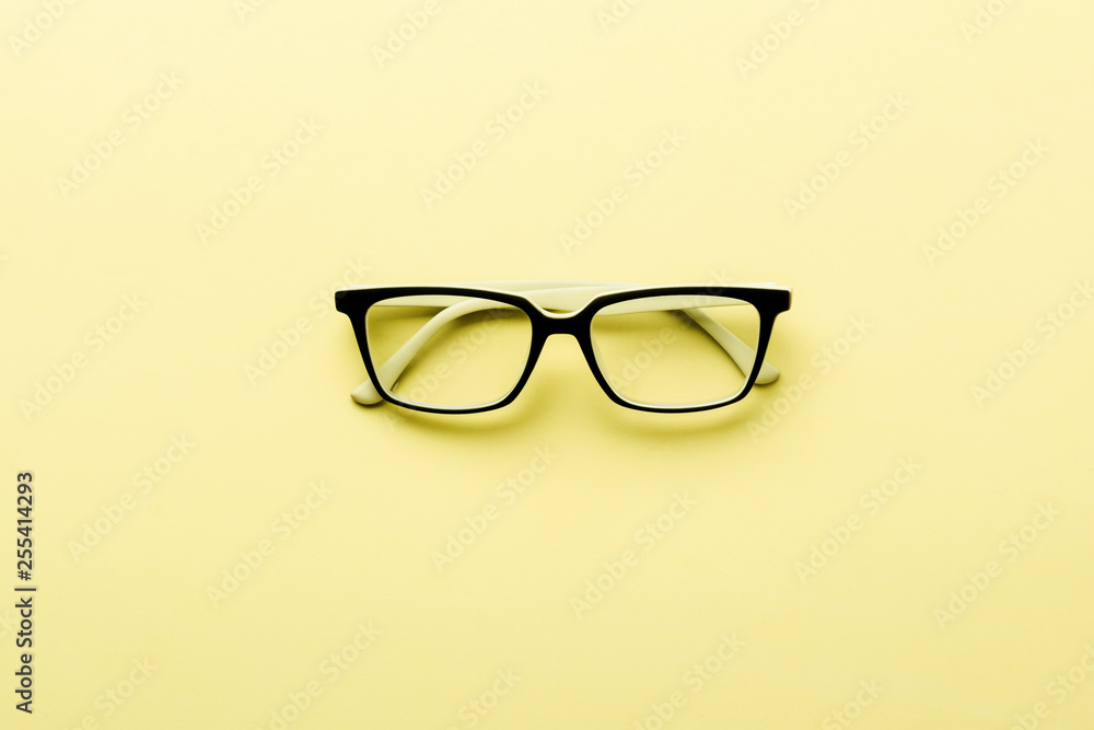 Modern spectacles eye glass isolated on yellow background. Top view. Modern spectacles eye glass isolated on yellow background. Top view.