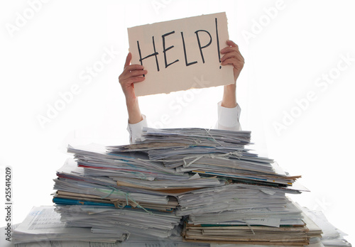 Person under a pile of papers with a hand holding a sign of help. Accounting.