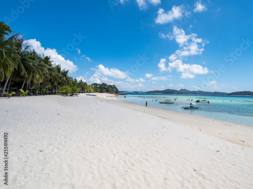 View of tropical beach on the island Malcapuya. Beautiful tropical island with sand beach, palm trees. Travel tropical concept. Palawan, Philippines. October, 2018 photo