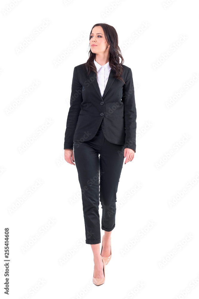 Successful elegant business woman in black suit walking and looking away. Full body isolated on white background. Successful elegant business woman in black suit walking and looking away. Full body isolated on white background.