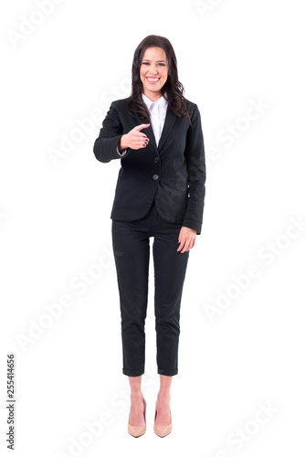 Laughing young business woman offering hand for handshake gesture. Full body isolated on white background.