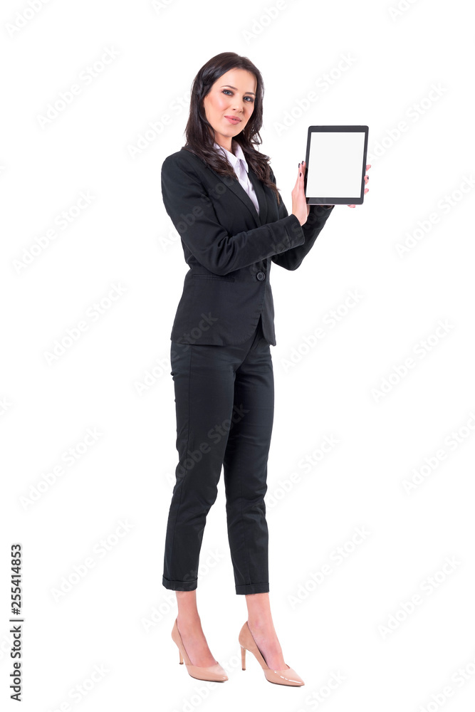 Satisfied smiling elegant business woman in suit showing and presenting tablet application. Full body isolated on white background. Satisfied smiling elegant business woman in suit showing and presenting tablet application. Full body isolated on white background.